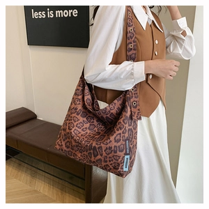 Close-up of leopard print canvas tote bag with detailed fabric texture and brand side label