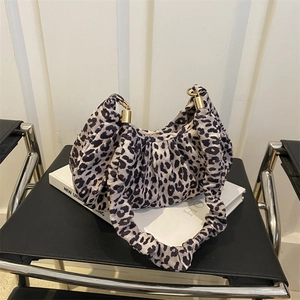 Detail of leopard print underarm bag featuring pleated texture and golden metal ring hardware