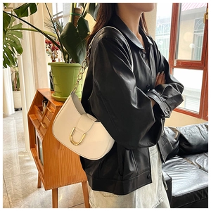 Chic white crescent saddle bag featuring gold metal buckle and leather chain strap detail