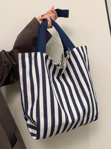 Detailed view of striped canvas tote bag with navy blue handles and large capacity