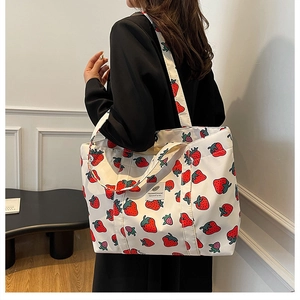 Detail of strawberry print tote bag showing large capacity and durable canvas material