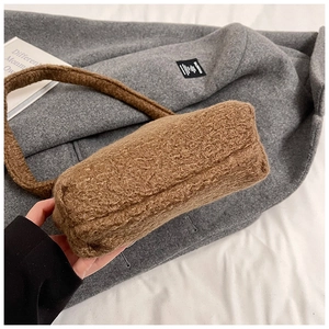 Détail macro de la texture en peluche marron et des coutures du sac hobo d'hiver