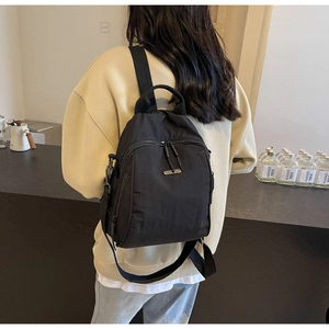 Detailed view of lightweight black nylon backpack with multi-pockets on model