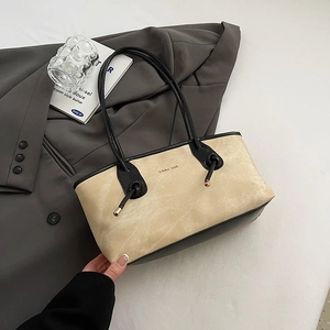 Fashionable beige suede tote bag with black leather handles for stylish daily commute