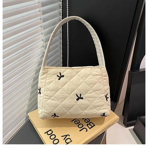 Détails du sac fourre-tout matelassé crème avec motifs de nœuds noirs brodés