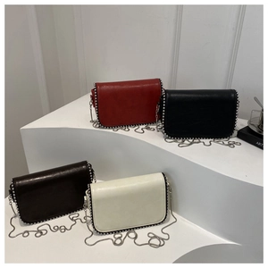 Detail view of stylish square chain bags with silver rivet trim in four elegant colors