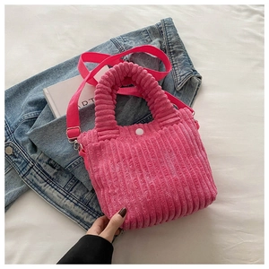 Detail of bright pink corduroy tote bag showing thick ribbed texture and white snap button
