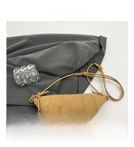 Detail showing soft khaki nubuck fabric and stitching on minimalist croissant bag