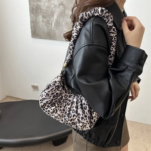 Close-up of leopard print shoulder bag featuring pleated texture on soft fabric material