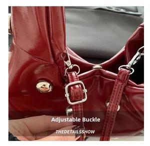 Détail macro du cuir verni rouge avec boucle réglable argentée et rivets métalliques