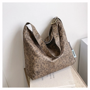 Close-up of leopard print tote bag detailing adjustable wide strap and metal hardware