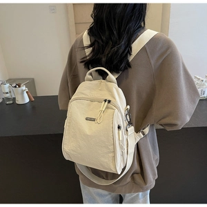 Detail of light beige water-repellent nylon backpack with woven handle and adjustable straps