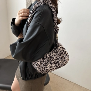 Side view of leopard print shoulder bag with pleated straps styled with leather jacket