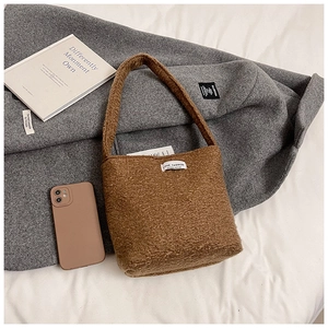 Détail du sac seau en peluche marron avec étiquette Love Fashion et texture douce