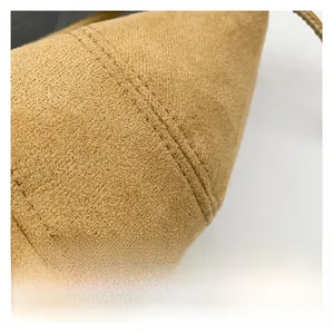 Detail of brown faux suede fabric with precise double stitching on crescent shoulder bag