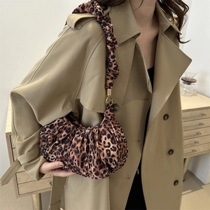 Close-up of leopard print shoulder bag featuring ruched strap and gold metal buckle