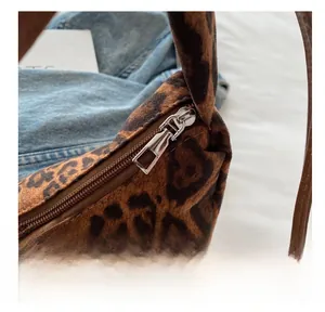 Close-up of a smooth silver metal zipper on a leopard print tote bag with soft texture