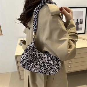 Detail of trendy leopard print underarm bag with pleated texture and wide shoulder strap