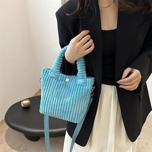 Light blue corduroy bucket bag with top handle and adjustable strap for women