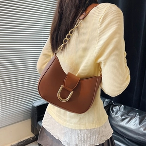 Brown half-moon underarm bag with gold chain strap shown from a side-back view