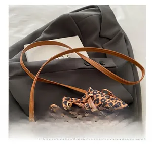 Close-up of leopard print bucket bag featuring brown PU drawstring and metal buckle