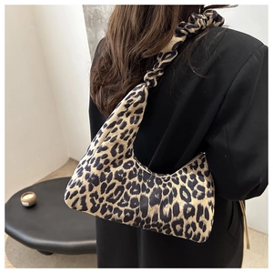 Detail of vintage leopard print crescent tote bag with scrunchie strap on model