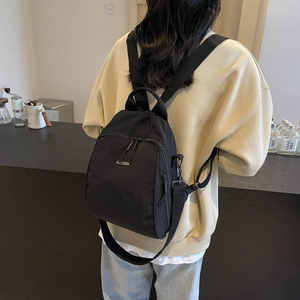 Versatile black nylon backpack for women with adjustable straps and metal zip details