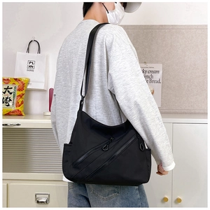 Détail du sac à bandoulière noir avec compartiments multiples et sangle ajustable