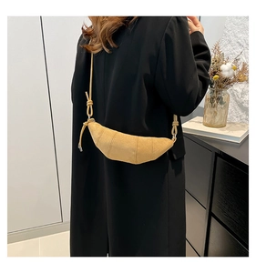 Detailed texture of ginger yellow suede croissant bag with stitched quilted folds