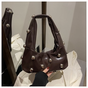 Vue détaillée d'un sac à main marron foncé brillant avec des rivets métalliques argentés