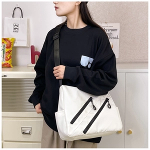 Détail du sac messager blanc en nylon avec zips noirs et bandoulière large réglable