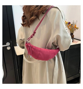 Detail of fuchsia crescent crossbody bag with frosted texture and knotted shoulder strap
