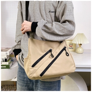 Détail latéral du sac messager en nylon kaki avec double fermeture éclair et sangle