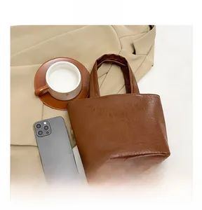 Top-down view of a minimalist brown tote bag with natural leather textures and round handles
