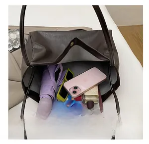 Top view showing large interior capacity of brown tote bag with phone and umbrella