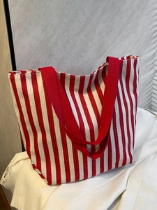 Detail of red and white striped canvas tote bag with thick red shoulder straps