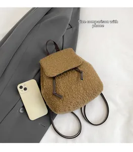 Close-up of brown plush mini backpack with size comparison to a smartphone