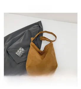 Close-up of brown suede hobo bag featuring a stylish knotted shoulder strap detail