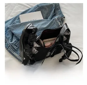 Macro view of butterfly embroidery bag showing large storage capacity for phone and cosmetics