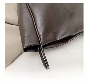 Detail of tight stitching and natural leather texture on a dark brown tote bag
