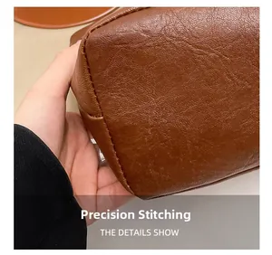 Detailed close-up showing precision stitching on brown pebbled leather tote bag surface