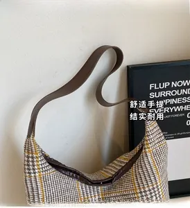 Detail of checkered tote bag with brown leather strap and classic houndstooth pattern