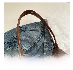 Detailed macro view of dark brown corduroy texture and sturdy leather handle stitching