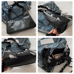 Detail of black butterfly embroidery and pleated shoulder strap on PU leather bag