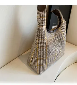 Detail view of vintage plaid hobo bag with soft woven texture and brown leather strap