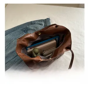 Detail view of brown large tote bag interior showing capacity for iPad and wallet