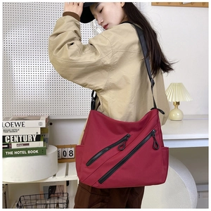 Détail du sac messager bordeaux imperméable avec double fermetures éclair diagonales