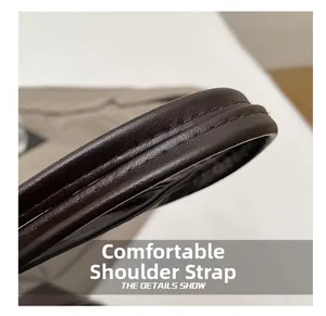 Detailed close-up of dark brown leather bag strap with durable double-stitched seams