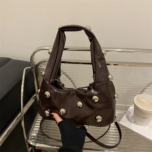 Sac à main en cuir marron foncé brillant avec boules métalliques argentées et plis chic