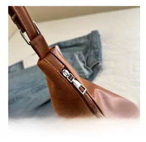 Close-up of smooth metal zipper and brown faux leather stitching on the bucket bag